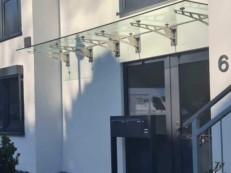 Ein weißes Gebäude mit einem Glasdach über der Tür