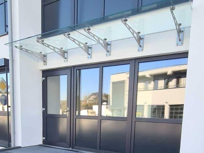 Ein Gebäude mit einem Glasdach über der Tür.