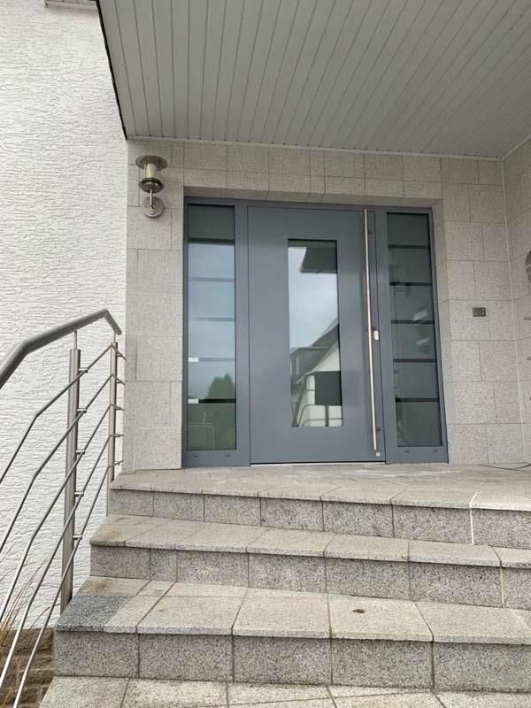 Die Eingangstür eines Hauses, zu der eine Treppe hinaufführt.