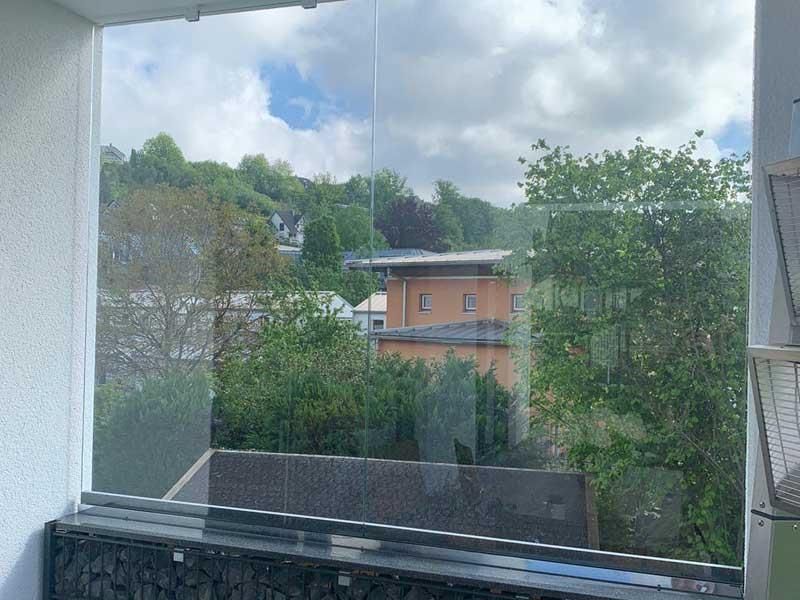 Ein großes Fenster mit Blick auf eine Stadt und Bäume.