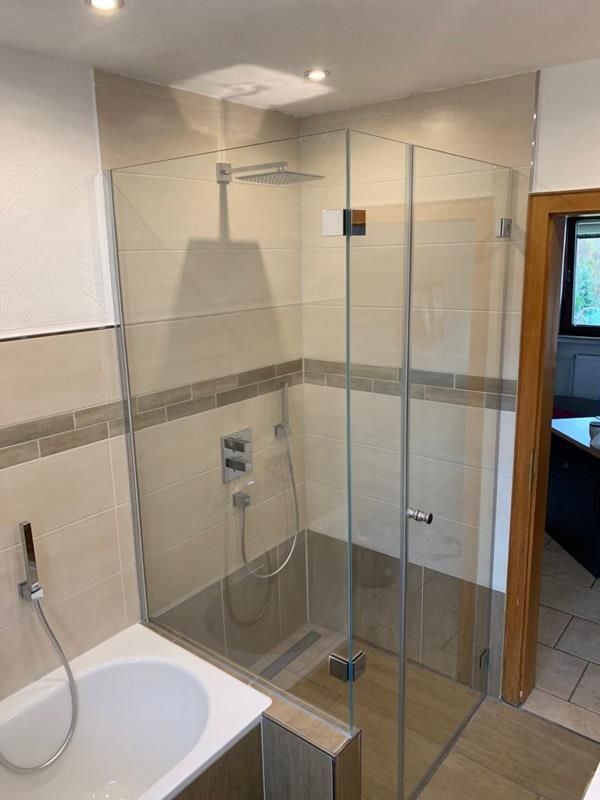 Ein Badezimmer mit ebenerdiger Dusche und Badewanne.