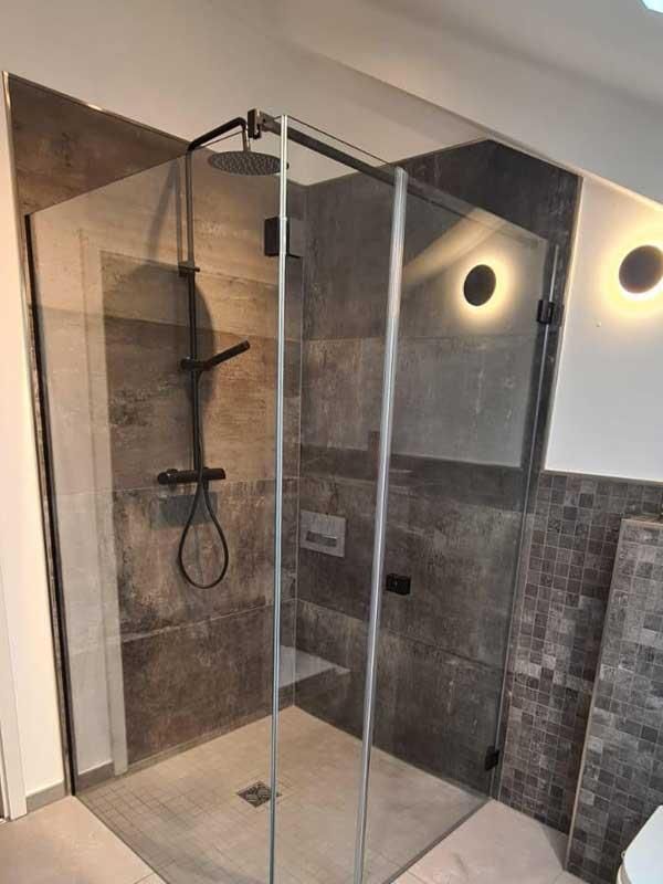 Ein Badezimmer mit ebenerdiger Dusche und Toilette.