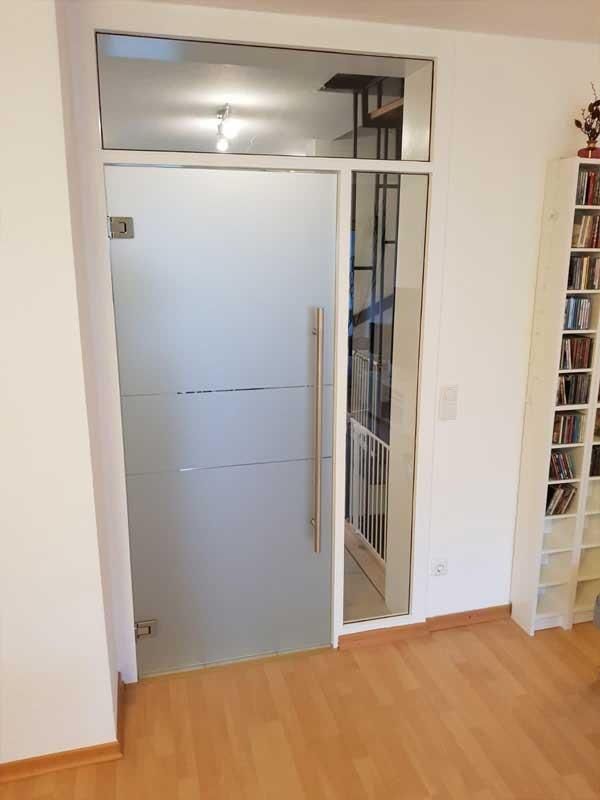 Ein Wohnzimmer mit Glastür und Bücherregal.