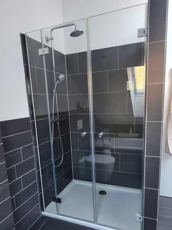 Ein Badezimmer mit ebenerdiger Dusche und Toilette.