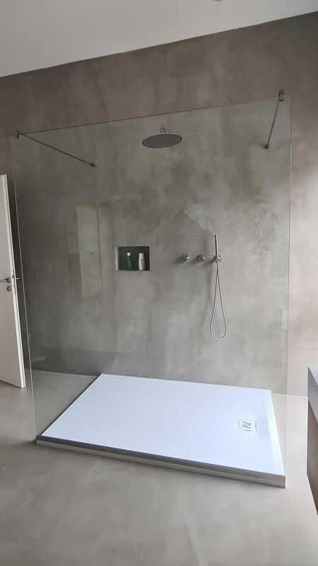 Ein Badezimmer mit ebenerdiger Dusche und weißer Duschwanne.