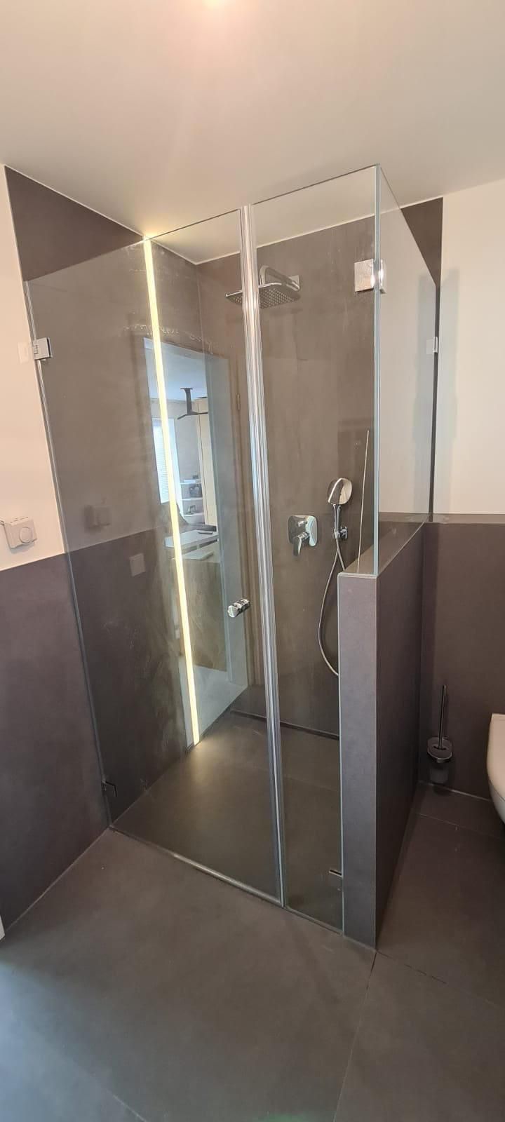 Ein Badezimmer mit ebenerdiger Dusche und Toilette.