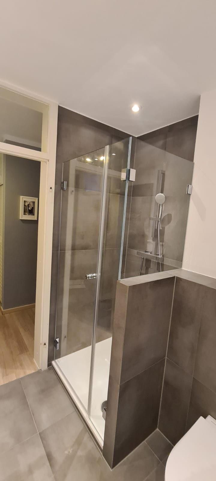 Ein Badezimmer mit ebenerdiger Dusche und Toilette.