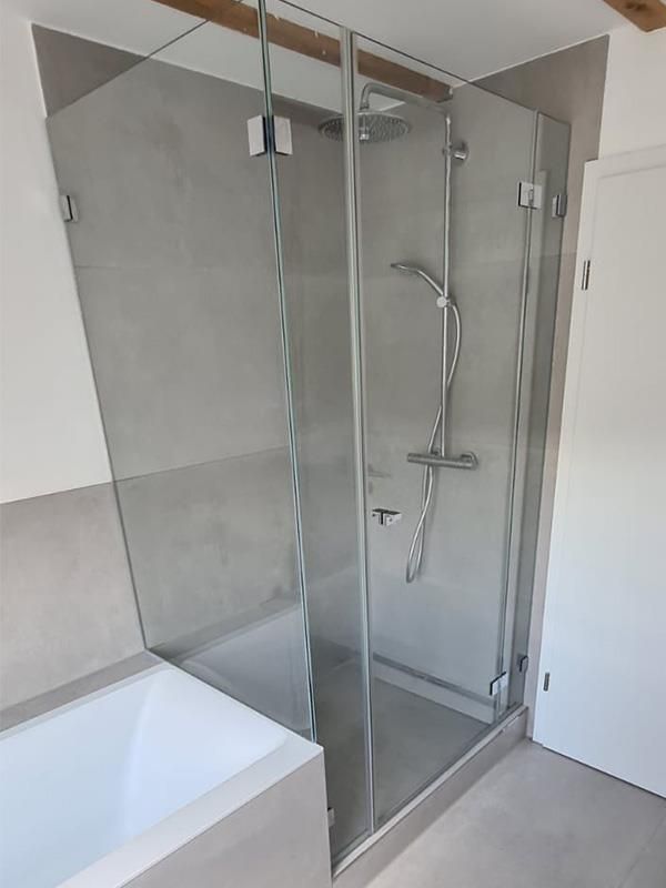 Ein Badezimmer mit ebenerdiger Dusche und Badewanne.