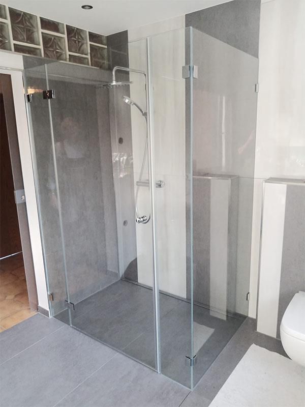 Ein Badezimmer mit ebenerdiger Dusche und Toilette.