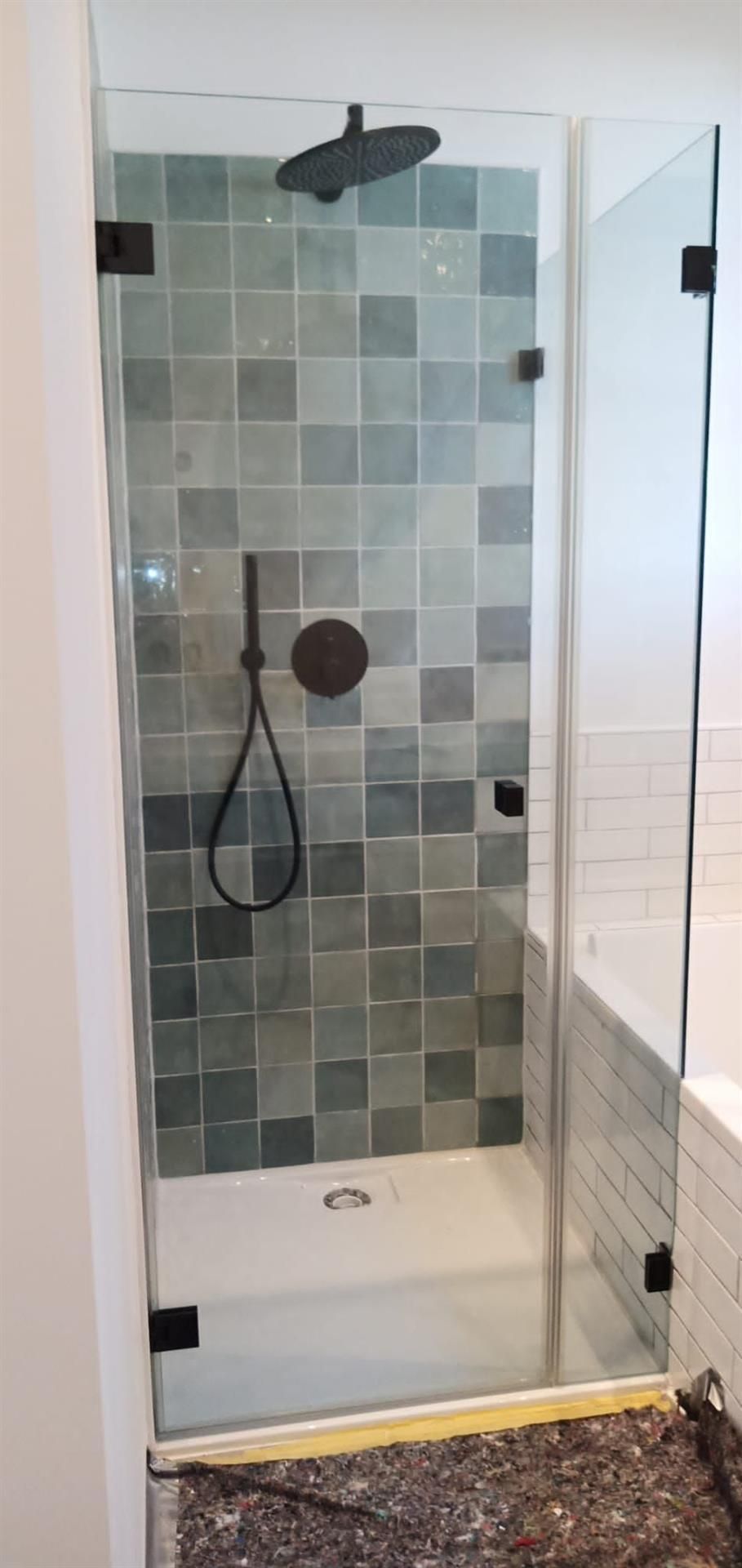 Ein Badezimmer mit Duschkabine und Duschkopf.