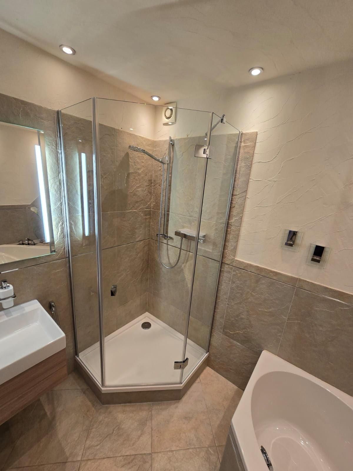 Ein Badezimmer mit ebenerdiger Dusche, Waschbecken und Badewanne.