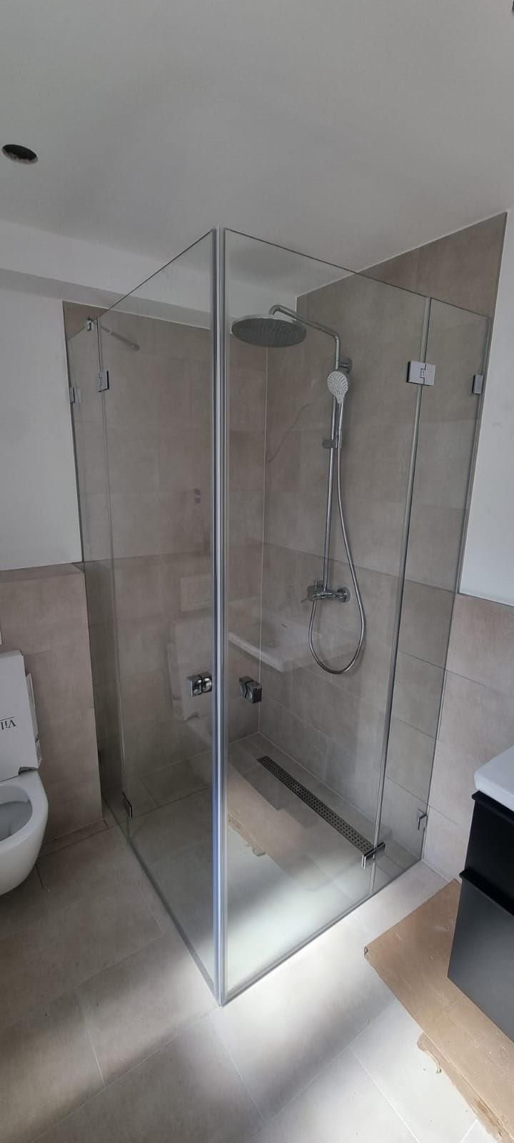 Ein Badezimmer mit ebenerdiger Dusche und Toilette.