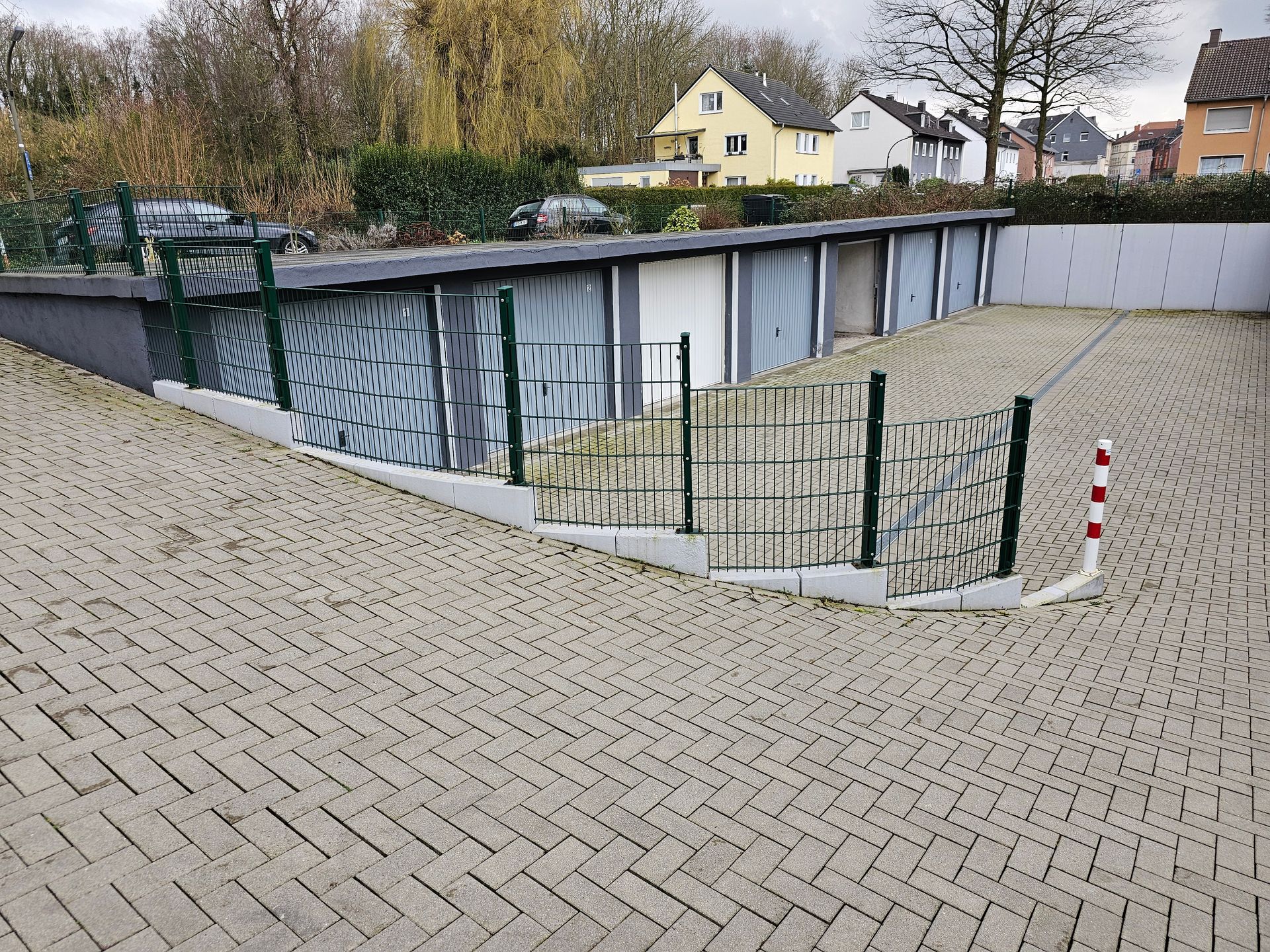 Eine Auffahrt, die zu einer eingezäunten Garage führt