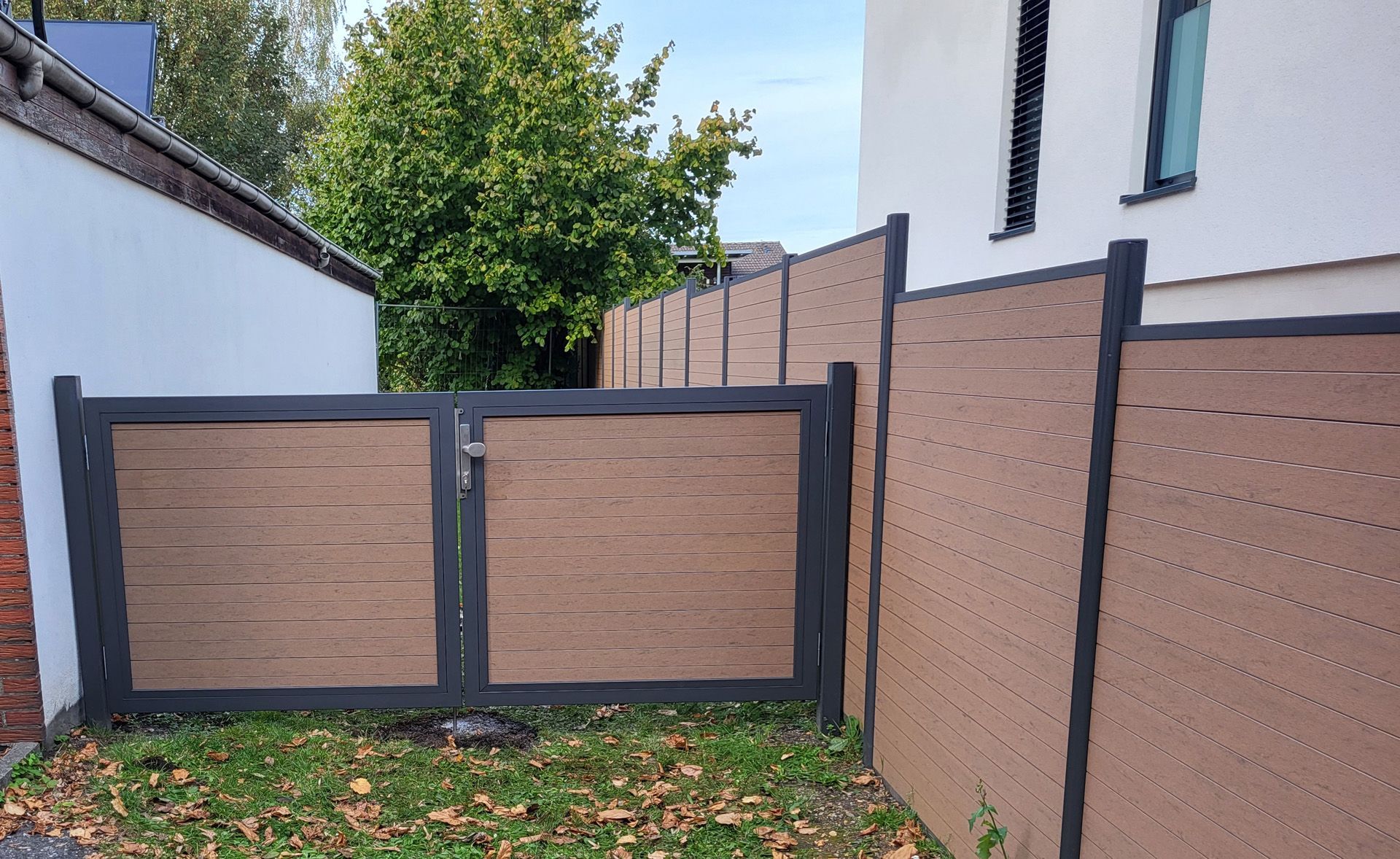 Ein Mann mit Schutzhelm und orangefarbener Weste arbeitet an einer Maschine auf einer Baustelle.