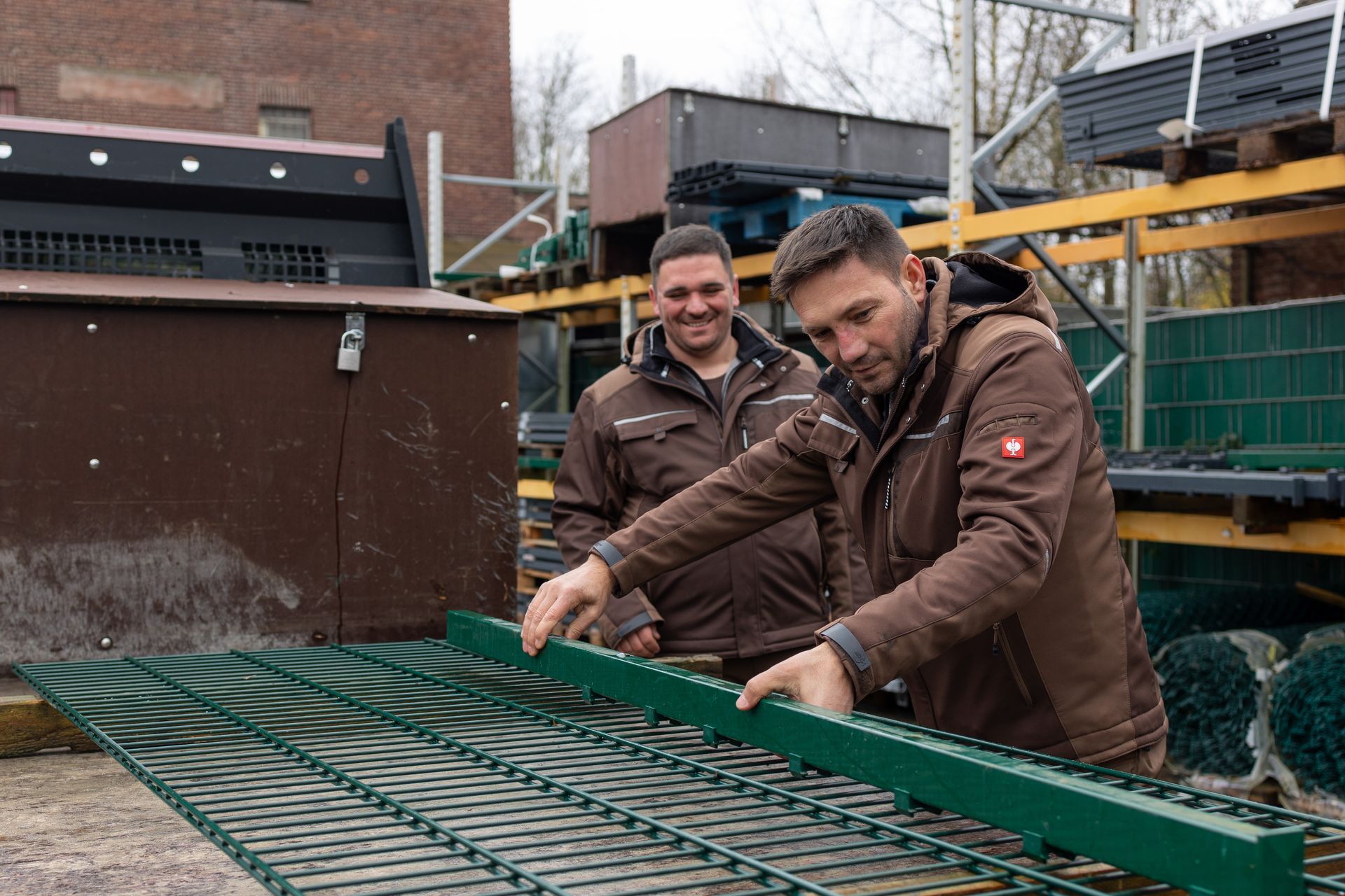 Zwei Männer arbeiten an einem Zaun bei GM.