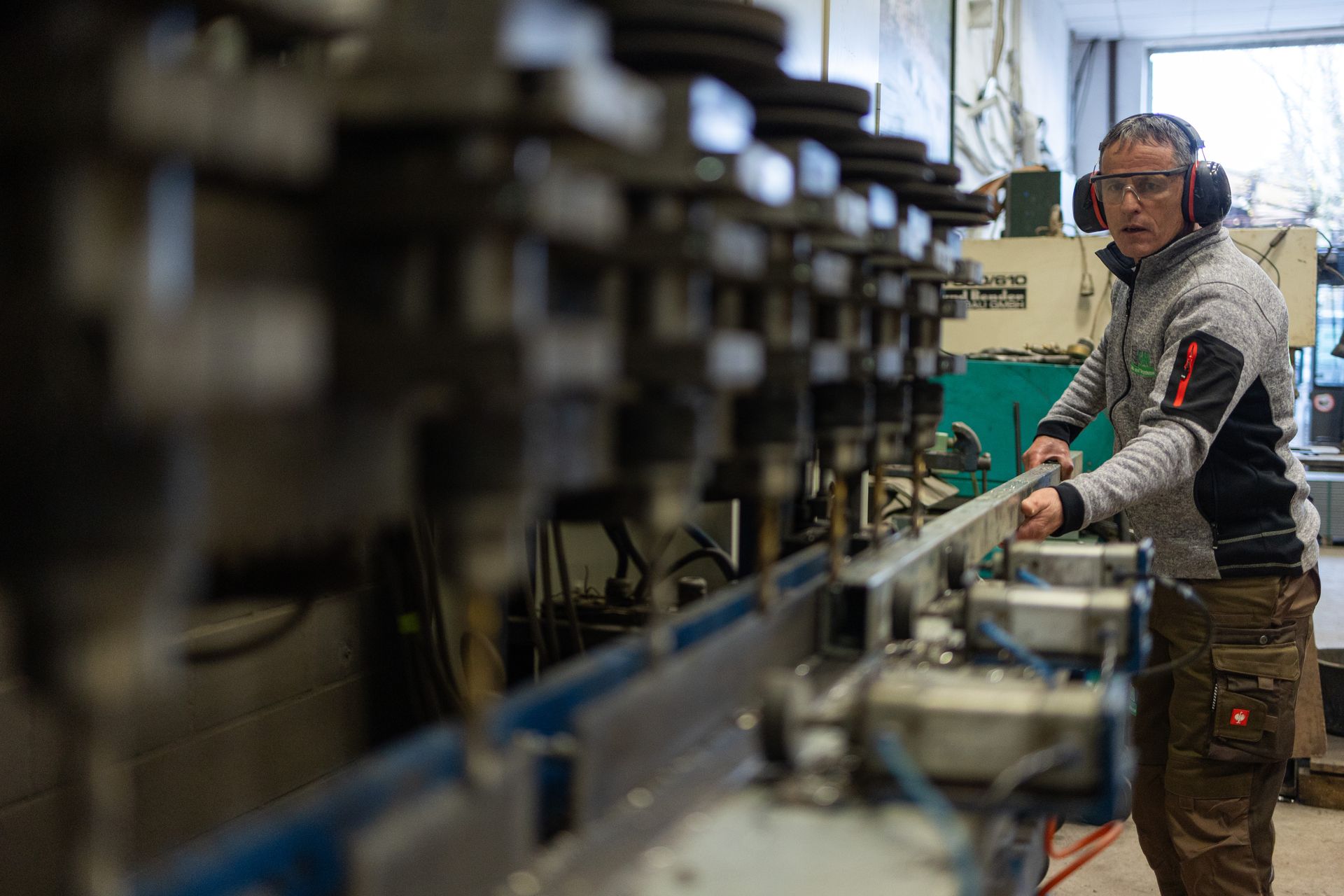 Ein Mitarbeiter arbeitet in einer Halle an einer Maschine.
