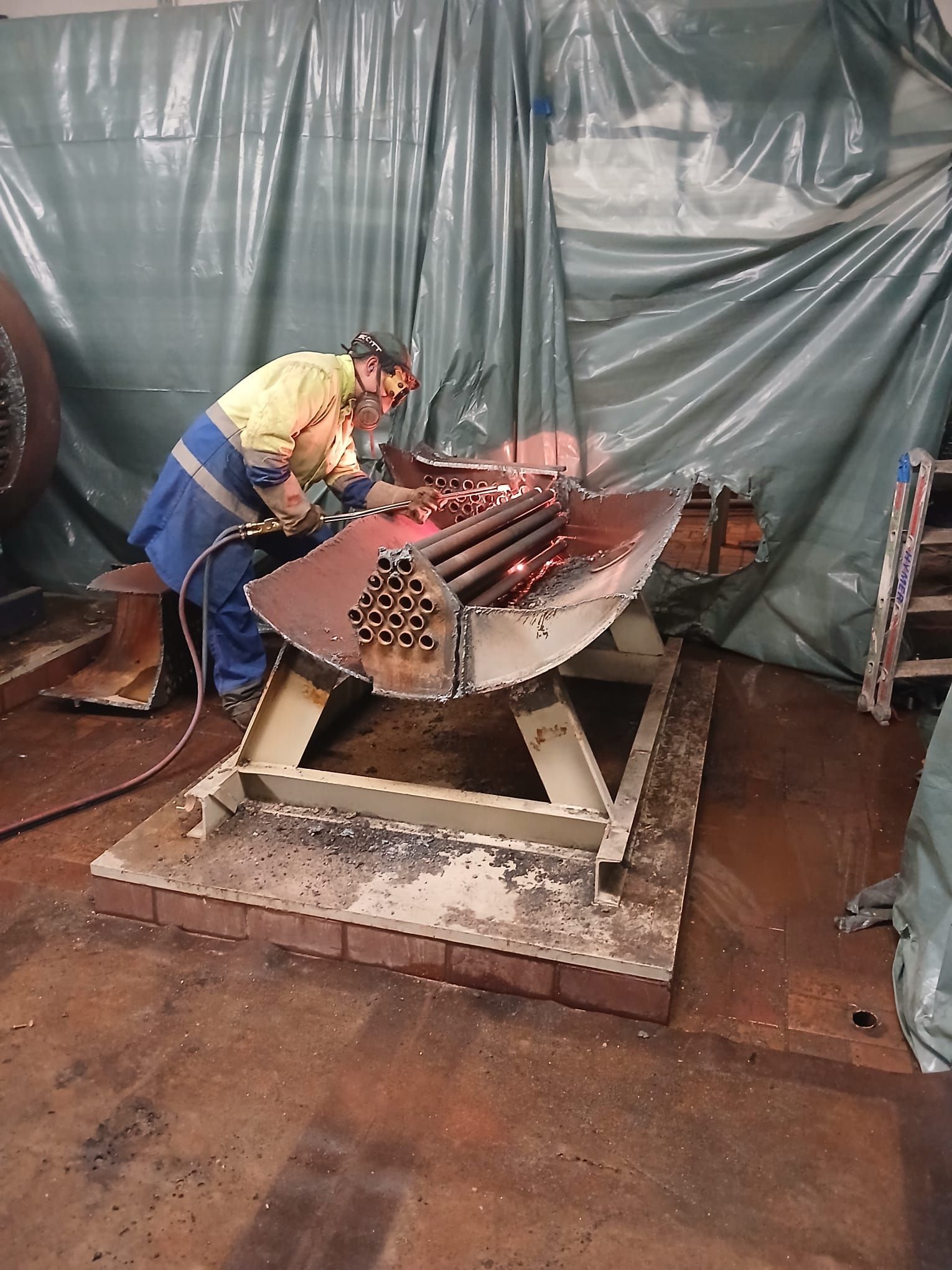 Ein Mann schweißt in einer Fabrik ein Stück Metall.