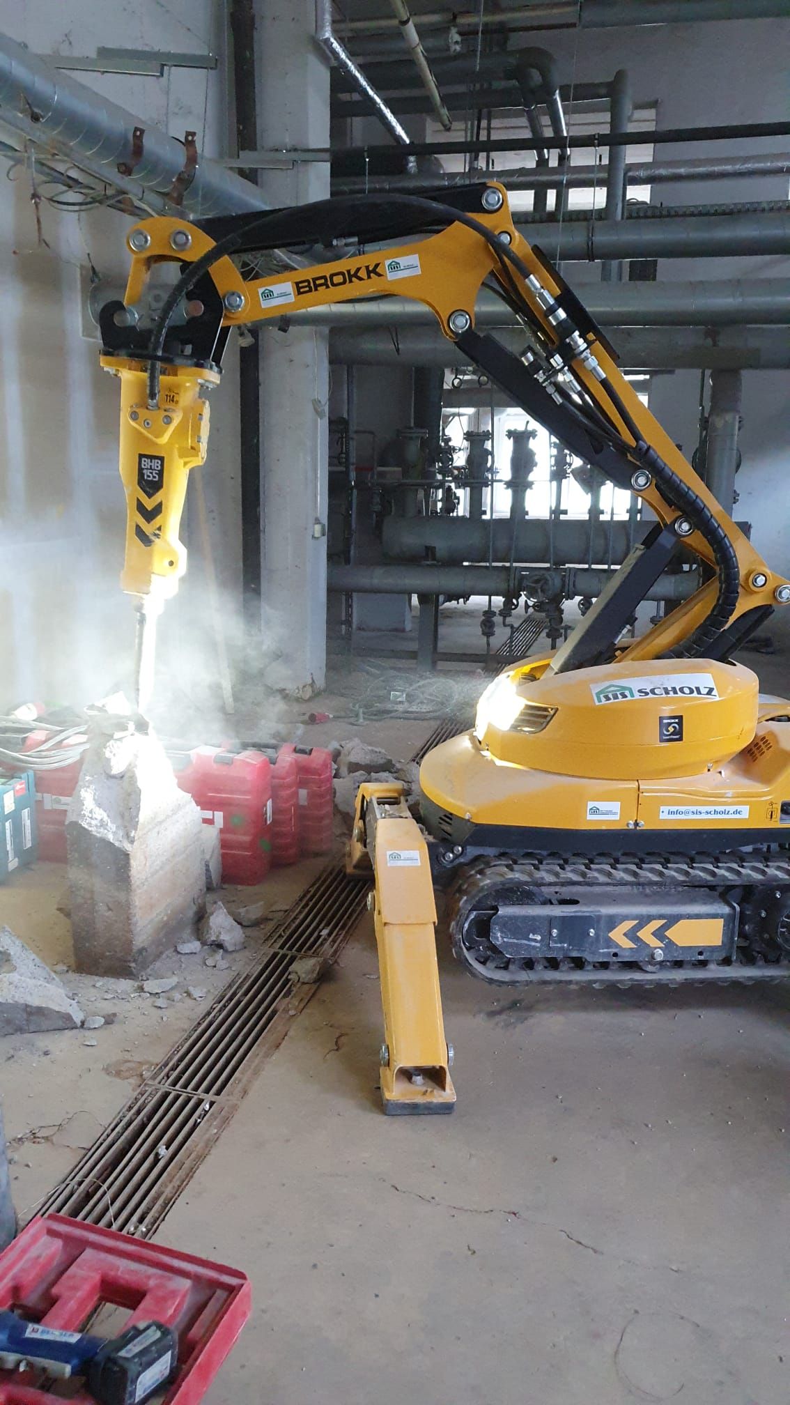 Ein Mann im Schutzanzug schweißt in einer Fabrik ein Rohr.