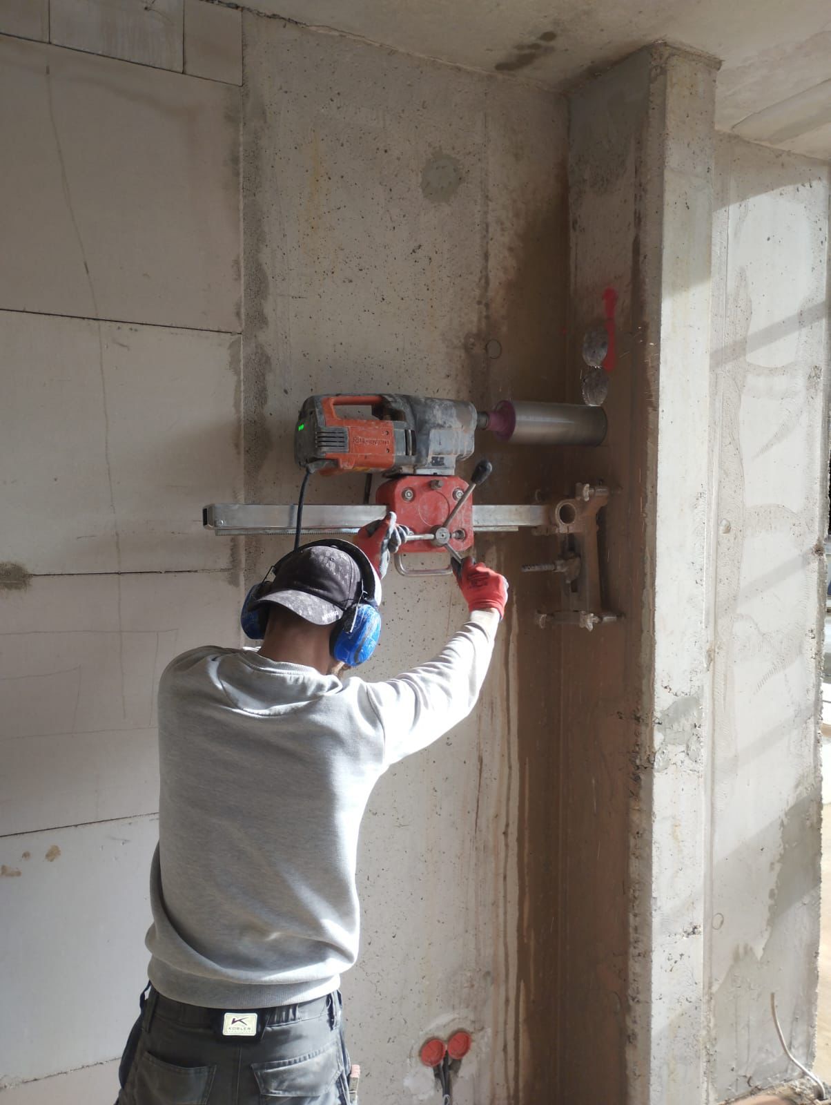 Ein Mann im Schutzanzug schweißt in einer Fabrik ein Rohr.