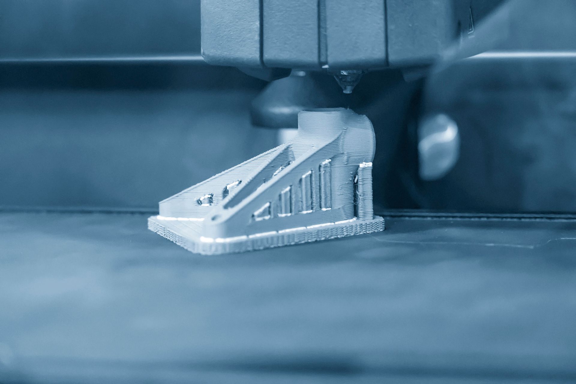 Eine Nahaufnahme eines 3D-Druckers, der ein Stück Metall druckt.