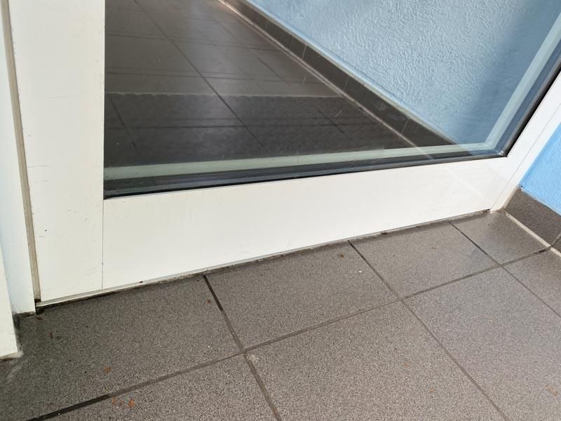 Eine weiße Tür mit einem gefliesten Boden davor