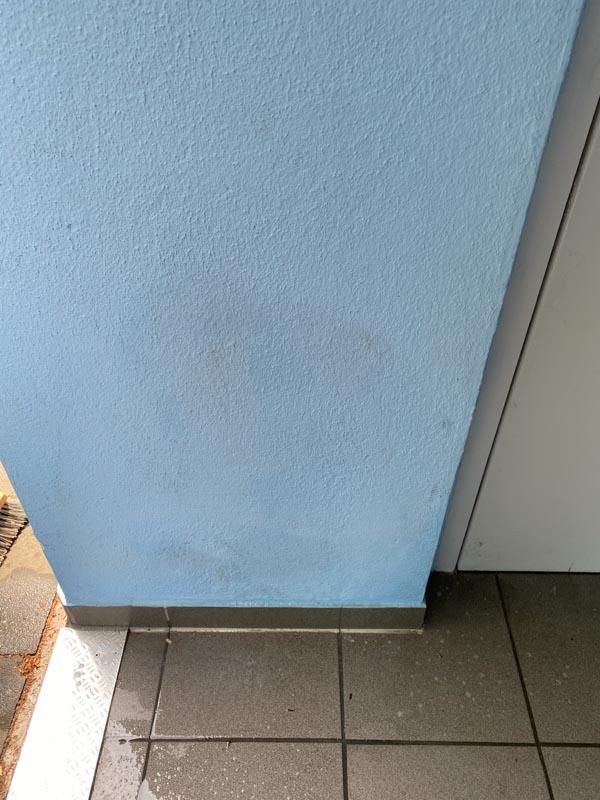 Eine blaue Wand ist neben einem gefliesten Boden