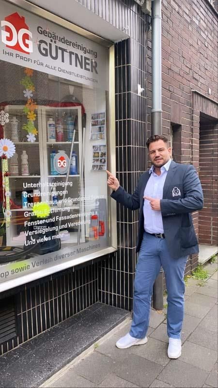 Ein Mann im Anzug steht vor einem Schaufenster.
