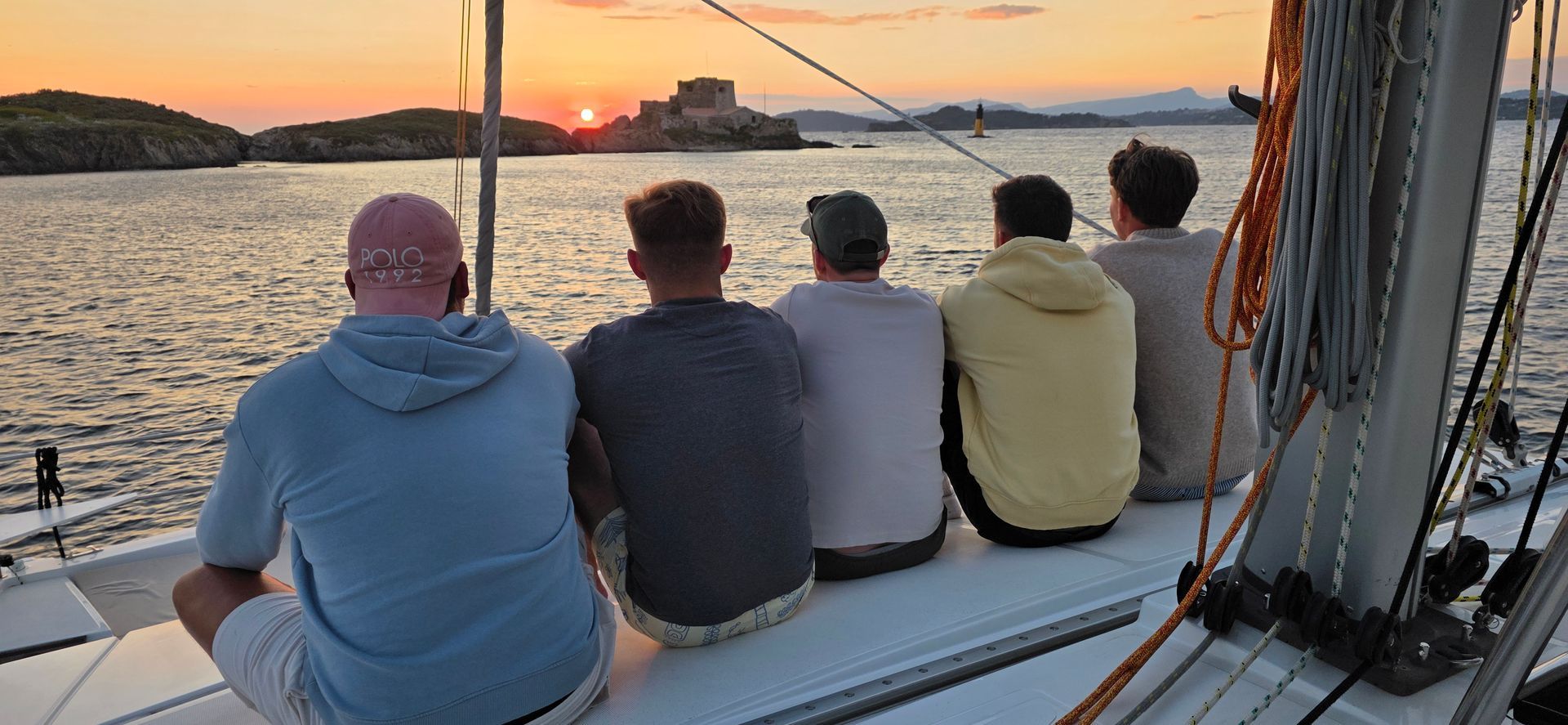 Deux voiliers ancrés dans des eaux turquoise près d'une île tropicale à la plage de sable fin.