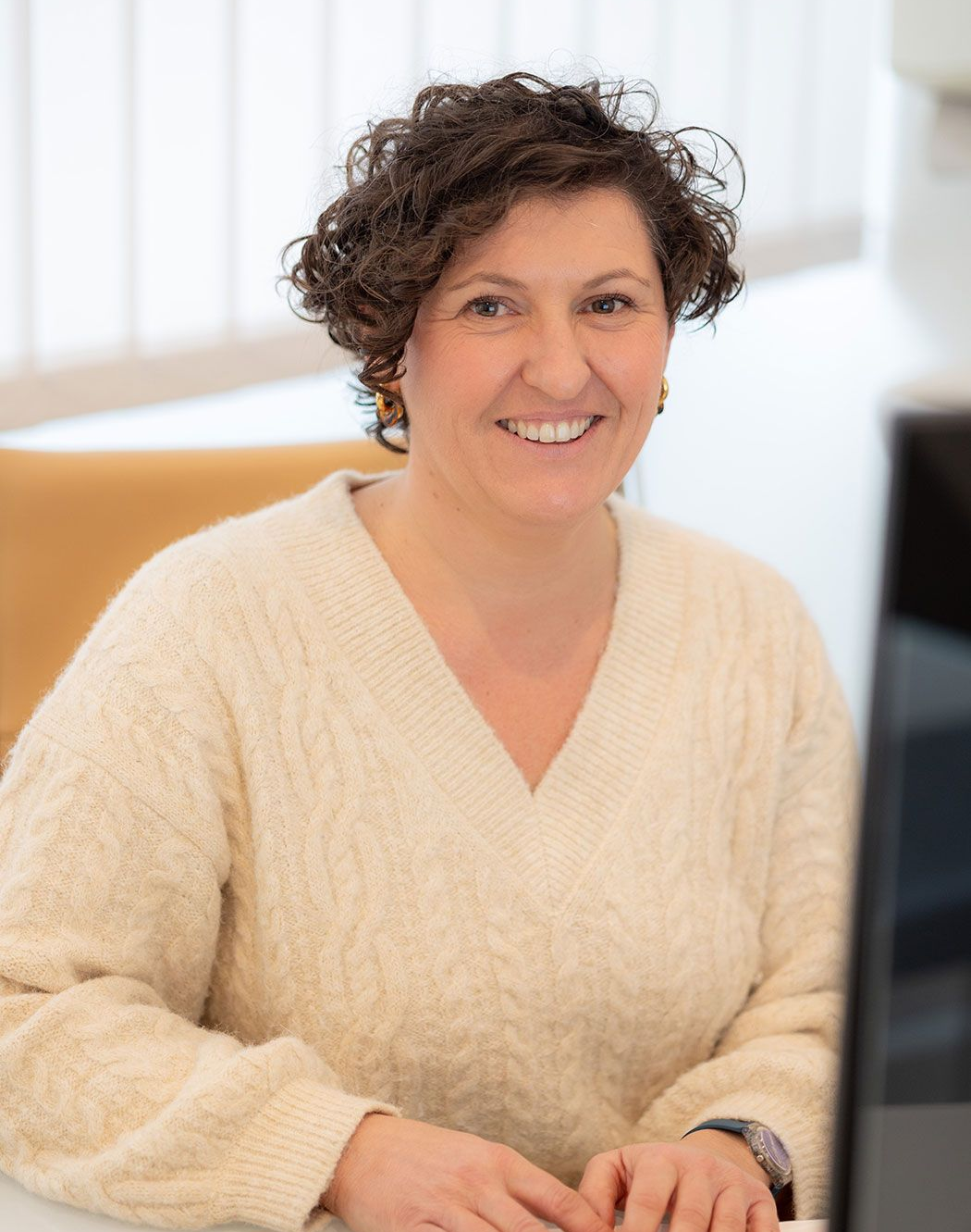 Frau Dr. med. Aurelia Offenbächer sitzt an einem Schreibtisch.