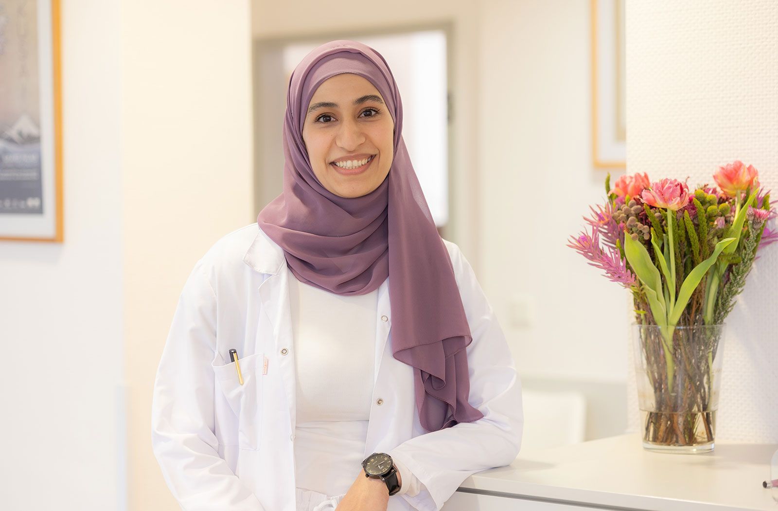 Nour Mkhaimer lehnt sich lächelnd an einen Schrank.