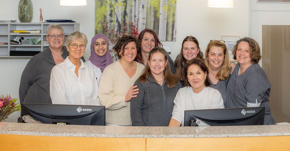 Die Mitarbeiter der Praxis Steins hinter dem Empfangstresen.