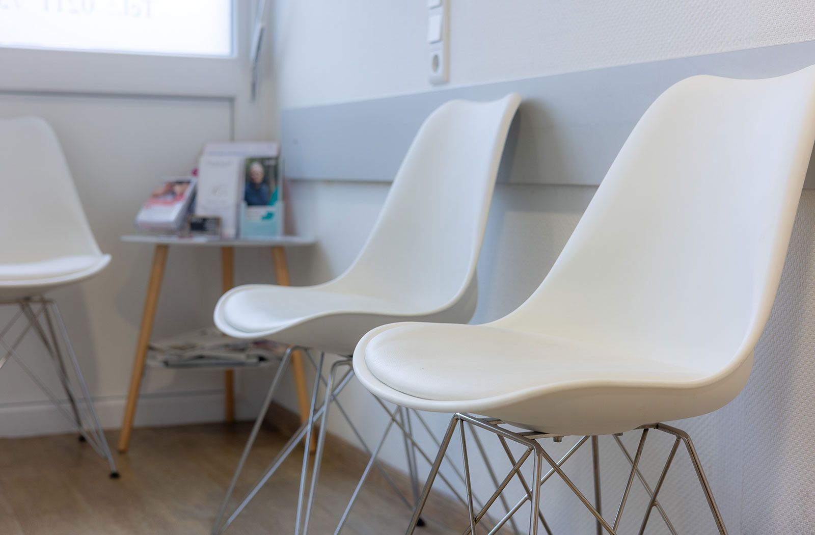 Stühle im Wartezimmer mit einem kleinen Tisch.