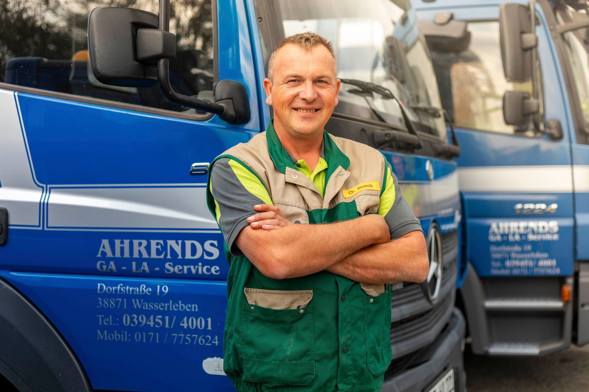 ein Mann steht vor einem blauen ahrends-LKW