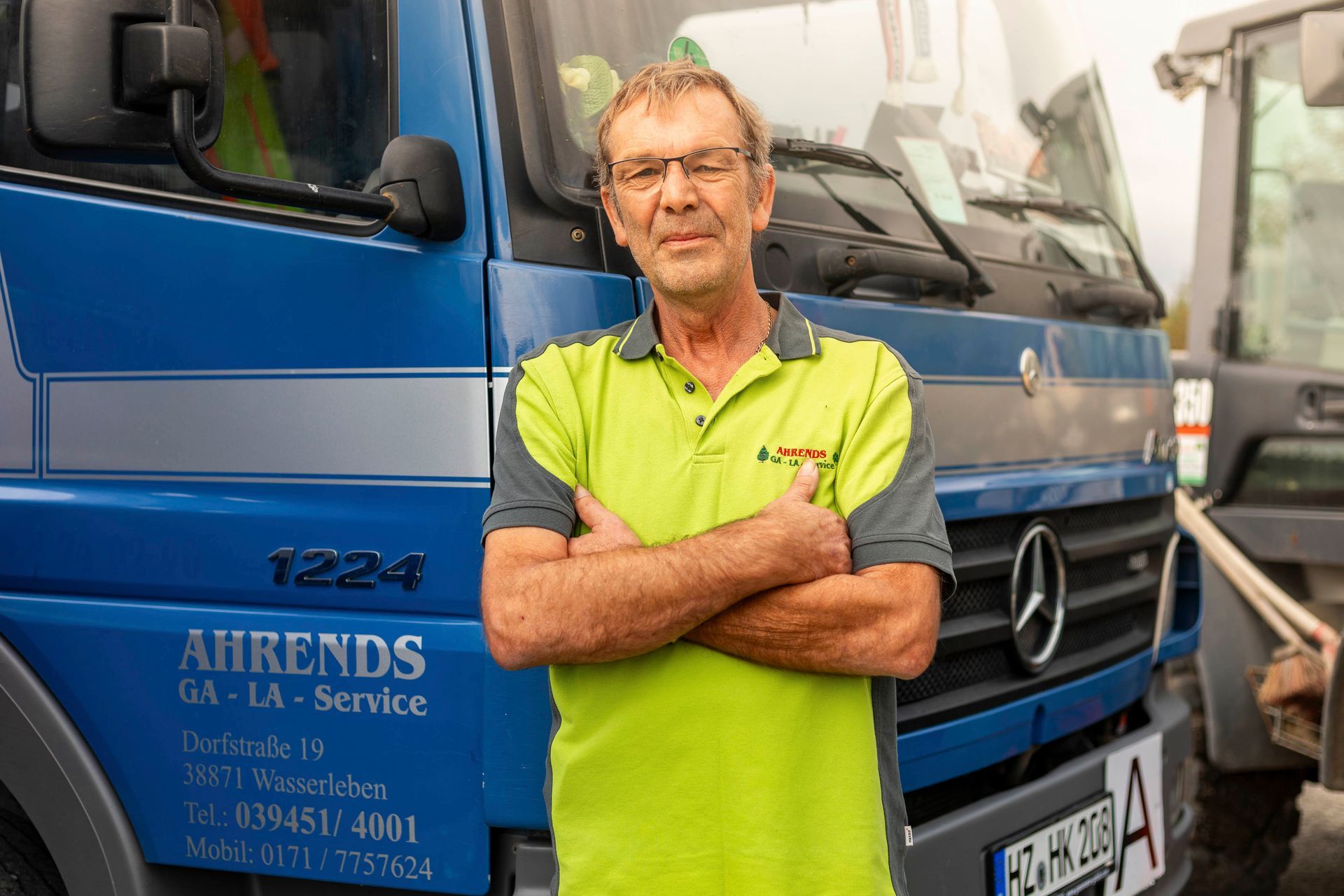 ein mann steht vor einem mercedes-lkw mit der nummer 1224