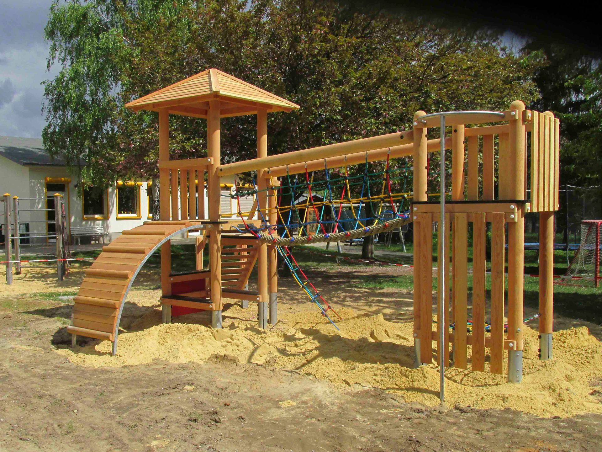 ein Holzspielplatz mit einem Turm und einer Rutsche