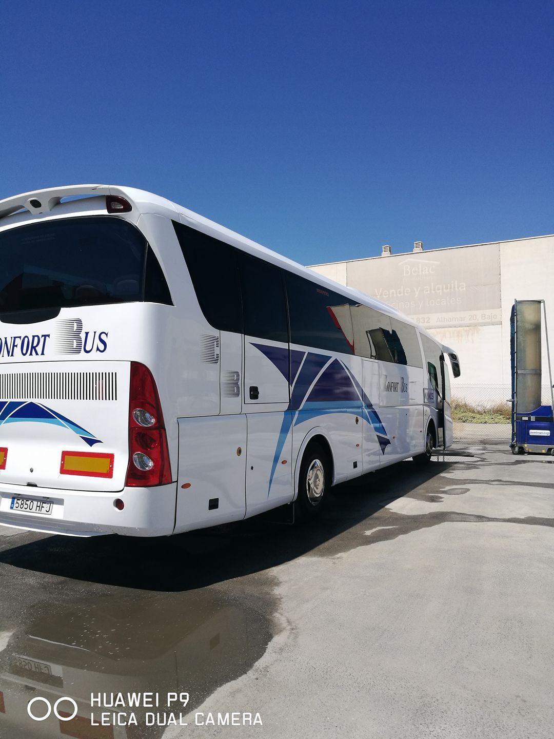 Un autobús blanco está estacionado en un estacionamiento.