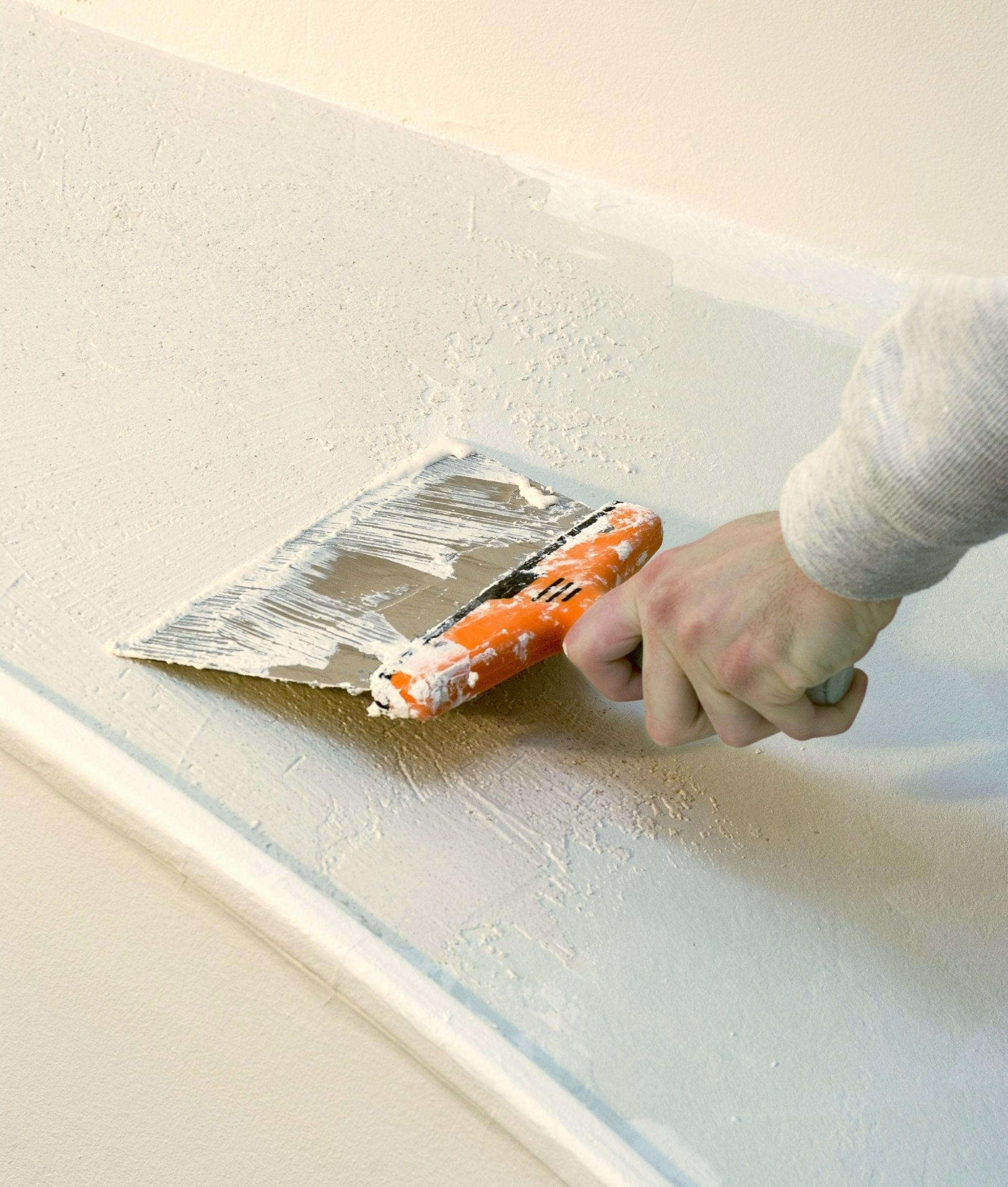 Main avec une spatule à plâtre