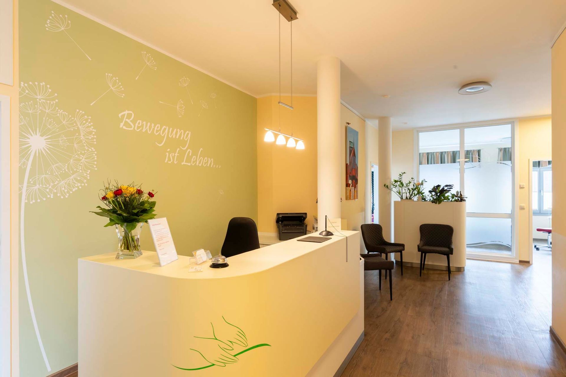 Ein Empfangstresen in einem Wartezimmer mit einer Vase mit Blumen darauf.