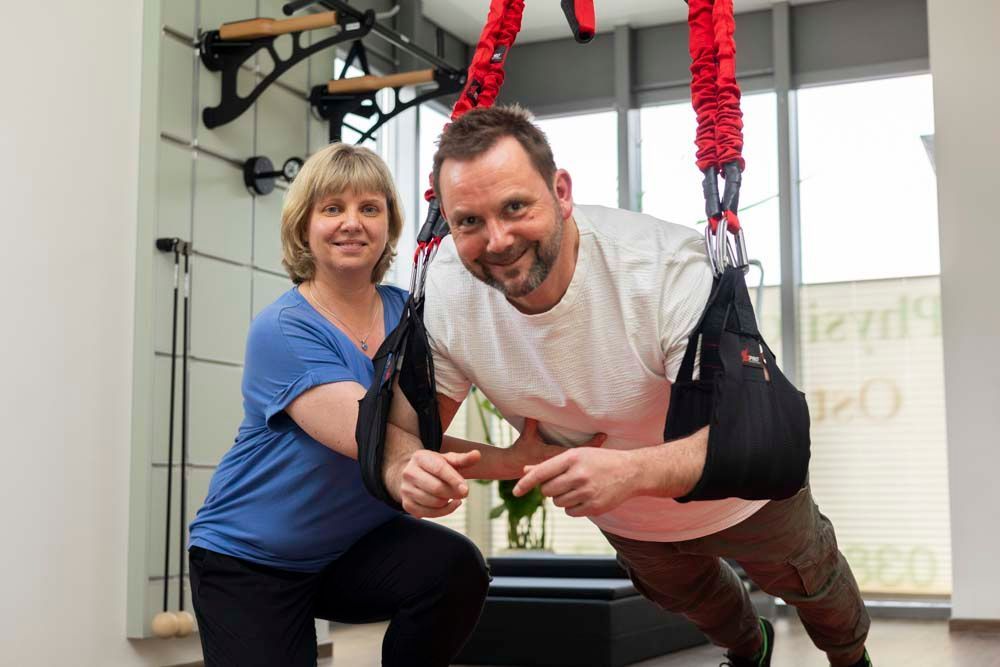 Ein Mann macht Liegestütze und neben ihm steht eine Frau.