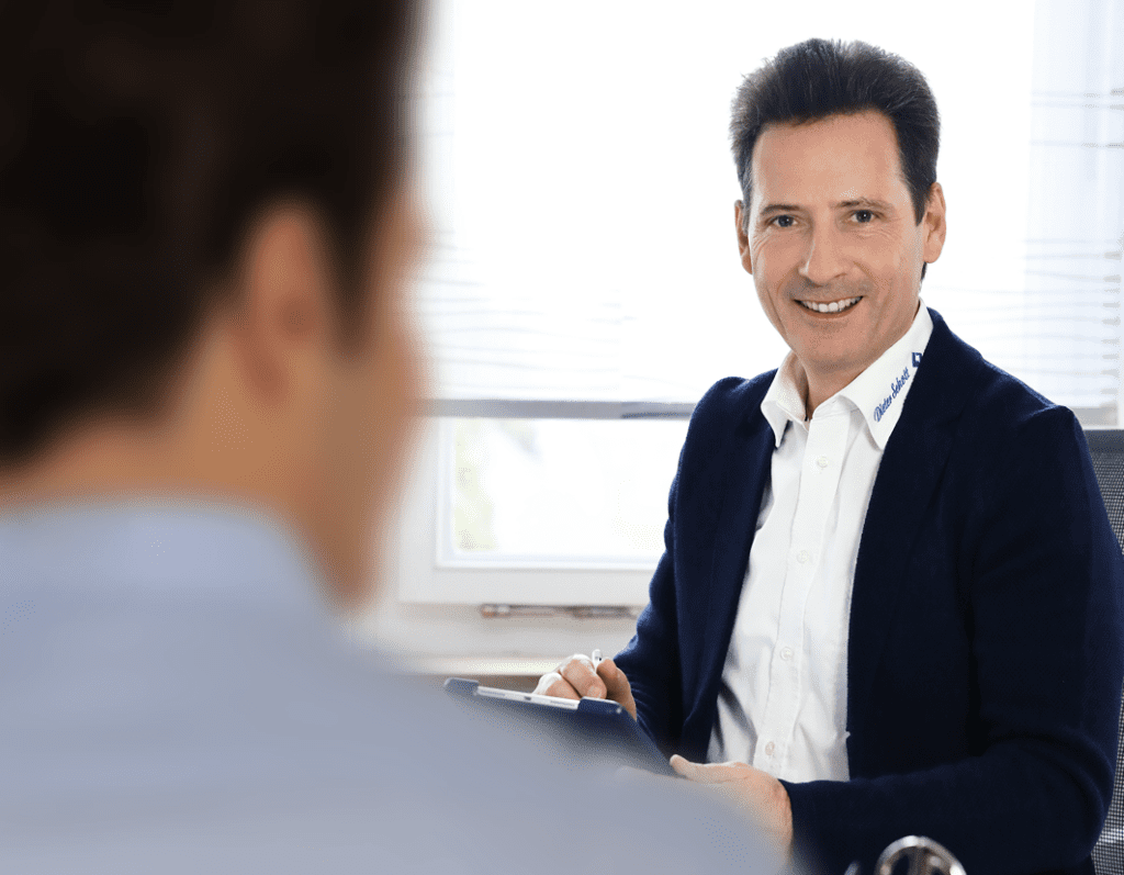 ein Mann im Anzug lächelt in die Kamera