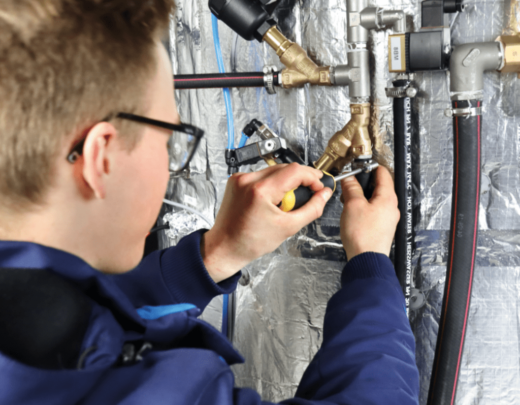 ein Mann arbeitet an Zuläufen für Autoklaven