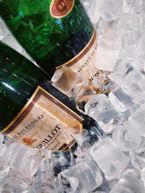 Two champagne bottles chilling in ice.
