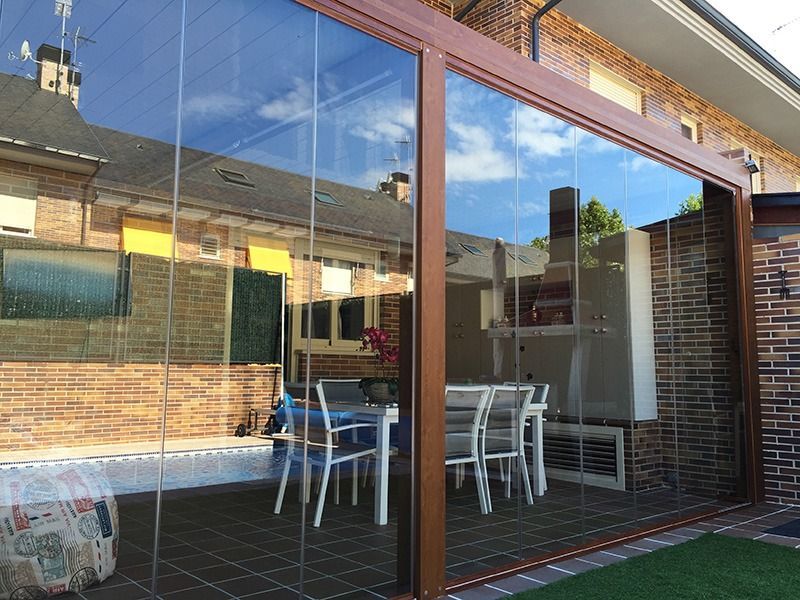 Cocina luminosa con puerta corrediza de vidrio y mampara retráctil, con vista a un patio y vegetación.
