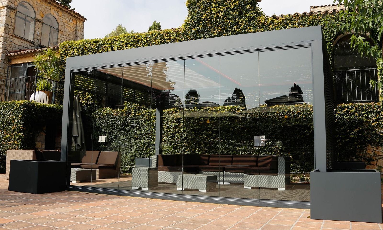 Cocina luminosa con puerta corrediza de vidrio y mampara retráctil, con vista a un patio y vegetación.