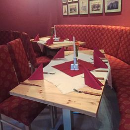 Innenansicht gedeckte Tische mit Stühlen und Sitzbänken