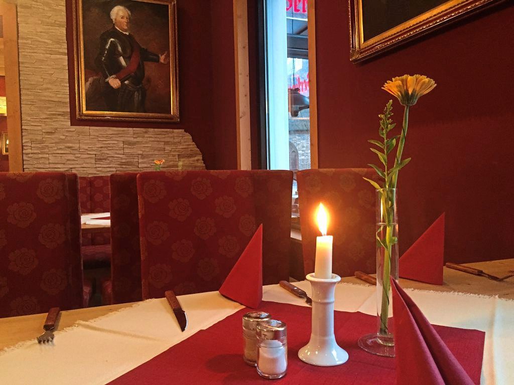 Innenansicht gedeckter Tisch mit Kerze und Blume