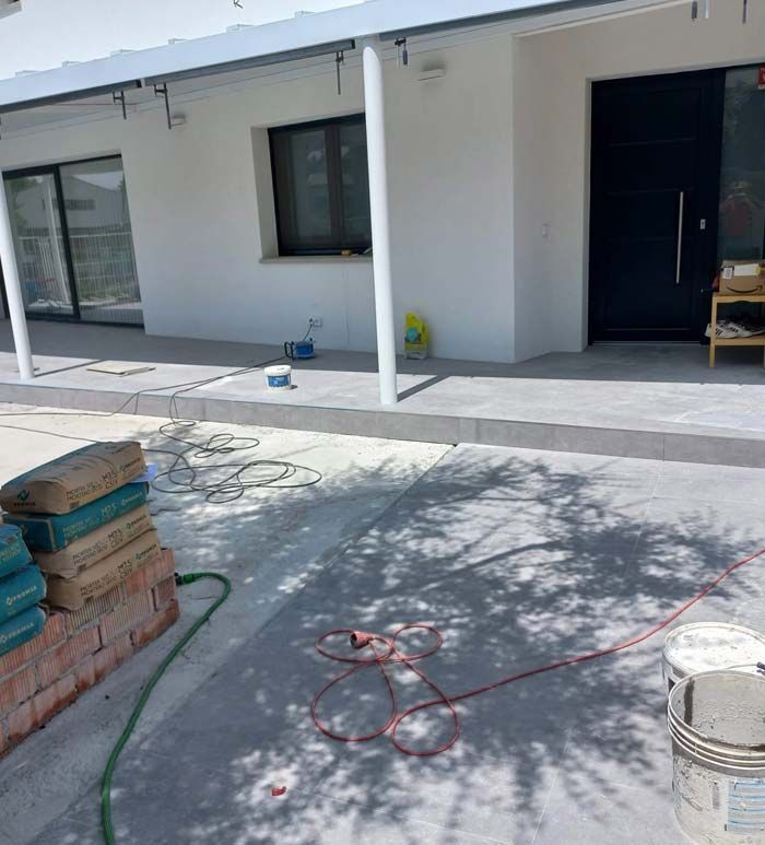 Un cubo de pintura está en el suelo frente a una casa.