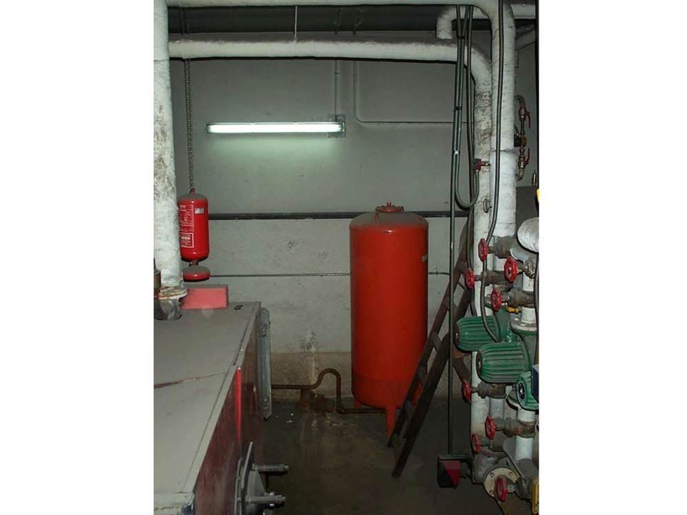 Una habitación con un tanque rojo y una escalera dentro.