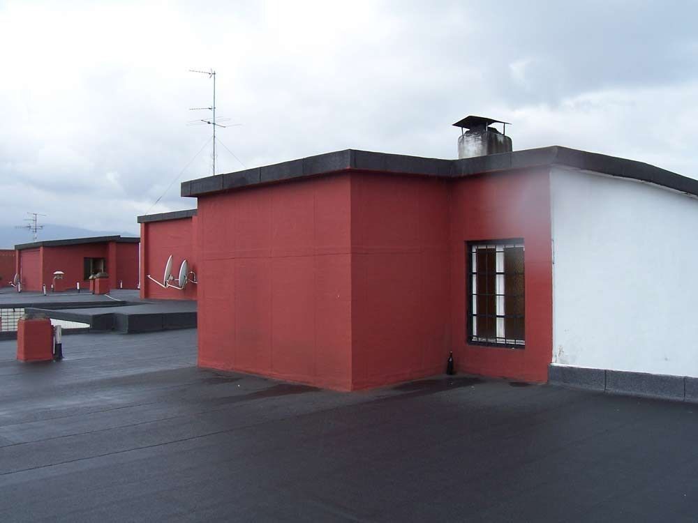 Un edificio rojo y blanco con una chimenea en el techo.
