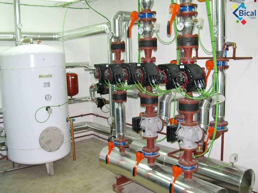 Una habitación con muchas tuberías y un logo bical en la pared.